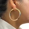 Large 18k hoop earrings worn by model
